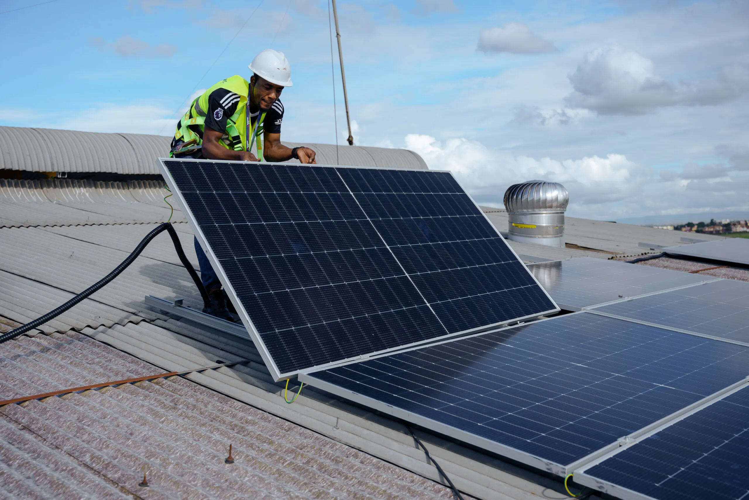 Solar engineer installing photovoltaic modules on an industrial roof